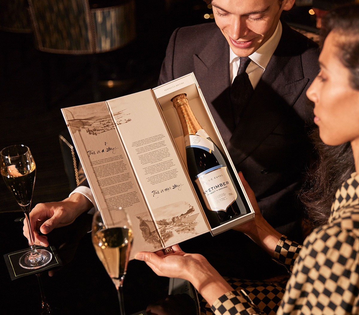 A woman holding open Nyetimber gift box with packaging illustrations for nyetimber by Matt Richards